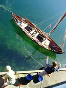 faering with mast and oars at quay in Norway, children fishing